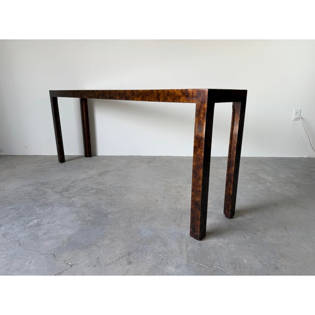 Elegant vintage console table by John Widdicomb featuring a striking faux tortoiseshell finish paired with a recessed...