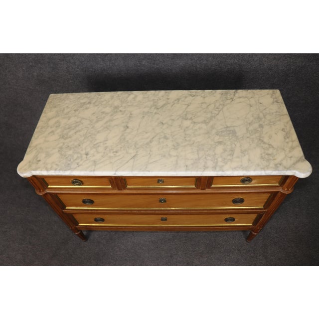 This elegant Louis XVI marble top commode embodies the disciplined grace of late 18th century French neoclassical design....