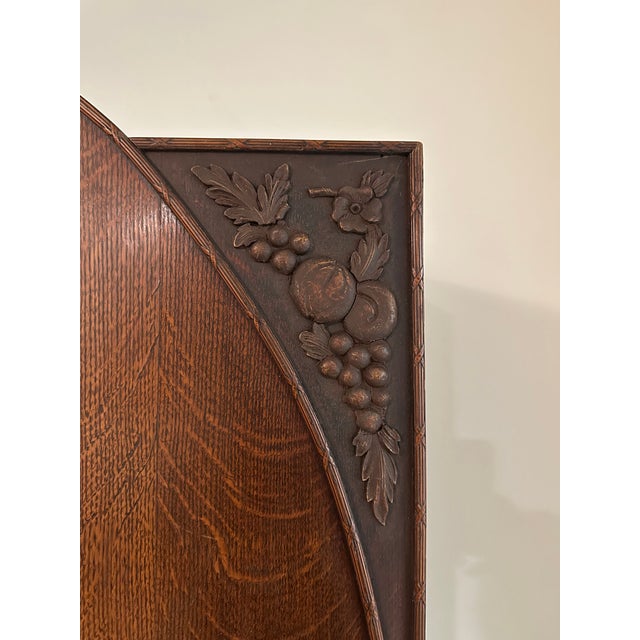 A traditional freestanding wardrobe armoire featuring a distinctive triple-panel facade with a central arched, beveled-...