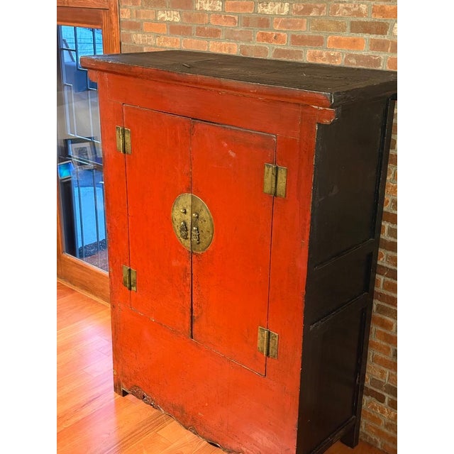 Beautiful Chinese-style cabinet finished in a rich red lacquer, featuring traditional brass hardware and double front...