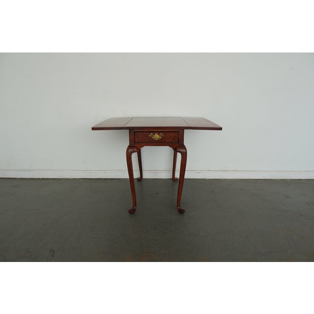 Made in the mid-20th century, this Hekman side table showcases classic Queen Anne–inspired form paired with a richly...