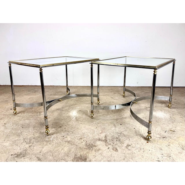 A pair of elegant, high-style, brass, chrome and glass Florentine side tables (unsigned) circa 1960’s. The tables feature...