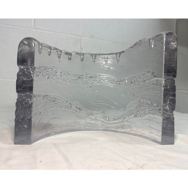 The Handmade Studio Glass Menorah by Joel & Candace Bless features a unique curved shape with a brutalist wave design,...