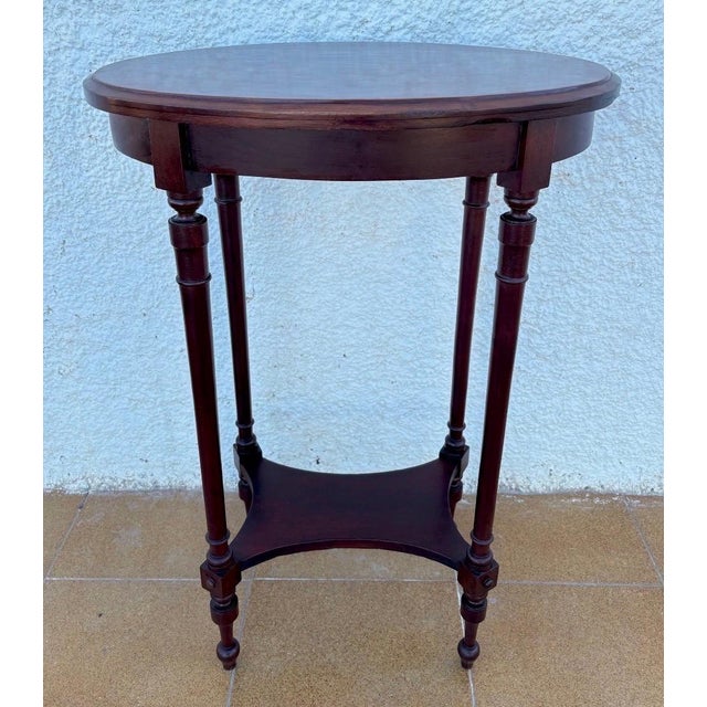 French mid-20th-century oak side table with an elegant oval top framed in wood, showcasing refined proportions and a...