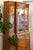 Three-section display cabinet with beveled glass doors, adjustable glass shelves, and lighting. Elaborate burl wood veneer...