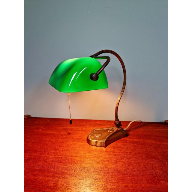 Articulated brass banker's lamp with a green opaline glass shade, 1920s-30s. Tension switch. Adjustable shade and tiltable...