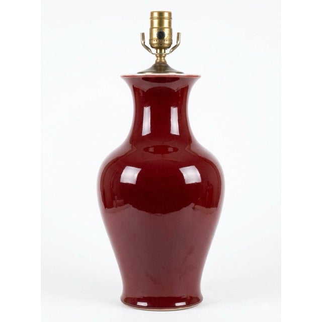 Fine quality Chinese porcelain Sang de Boeuf Oxblood Red lamp with fabric shade. Extraordinary glaze. This lamp is quite...