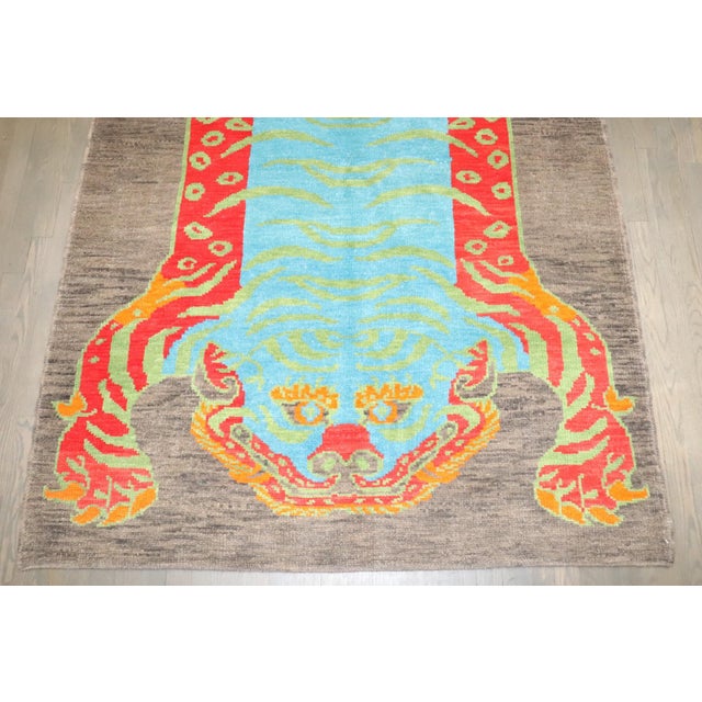 A striking modern hand-knotted Turkish pictorial rug featuring a boldly stylized tiger rendered in vivid, high-contrast...