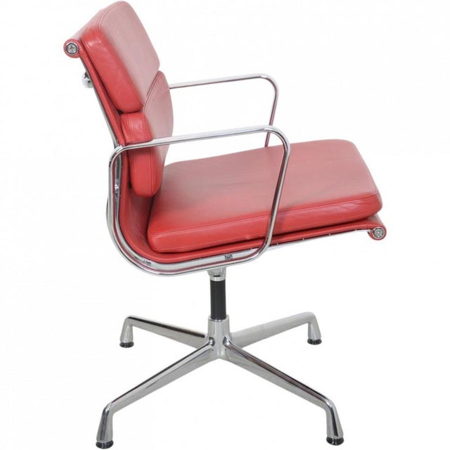 Charles Eames EA-208 Softpad chair upholstered in red leather, and with a chrome frame. The chair is from 2005 and appears...