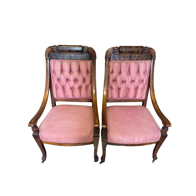 Elegant pair of Empire-style walnut armchairs featuring gracefully curved arms, carved turned arms supports, and rolled...