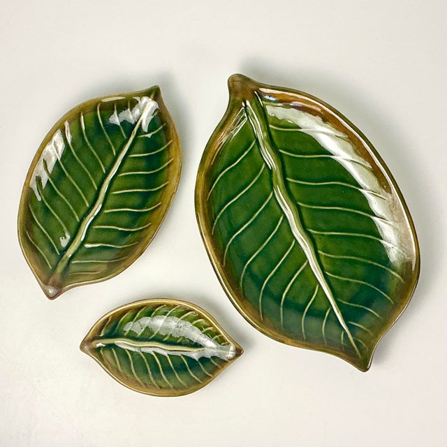 We love this set of three earthenware ceramic serving dishes in the Trompe L’Oeil style of banana leaves. They have a...