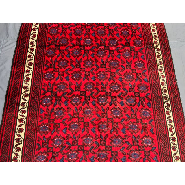 This vintage Afghan Baluchi hand-knotted rug is a captivating example of traditional tribal artistry, featuring a detailed...