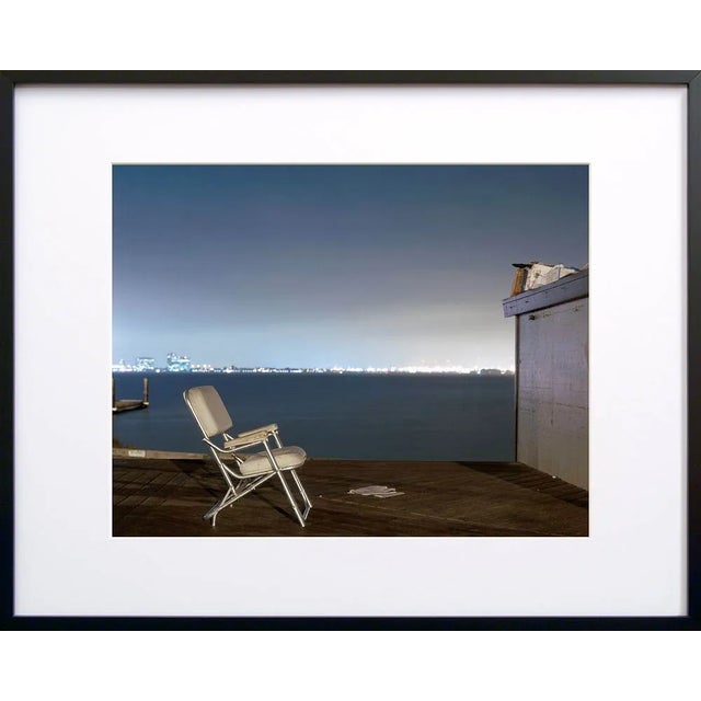 Note from the artist, John Vias: "Why does this chair face a blank wall?" This 16" x 20" archival color photograph is...