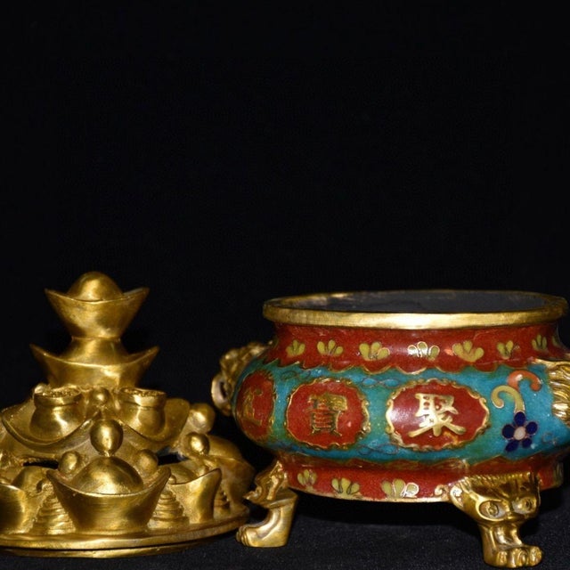 Ornate cloisonne enamel tripod censer decorated with vibrant red and turquoise enamel panels, accented by gold scrollwork...