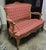A beautifully carved French Louis XV-style giltwood settee featuring a graceful serpentine silhouette, floral and foliate...
