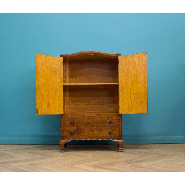 1930s Art Deco tallboy in figured oak with a serpentine front. The doors are finished in tiger oak veneer with a bold...