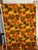 This is a 60s/70s mid-century heavy cotton barkcloth fabric featuring a bold marigold, orange, and earth-toned flower...
