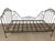 An exceptional, authentic 19th-century French wrought iron campaign daybed featuring striking, intricate scrollwork on the...