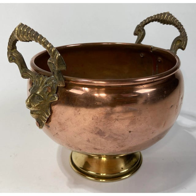 Large copper compote bowl featuring exaggerated brass rams head handles atop brass pedestal base. Patina to metal. Dents...
