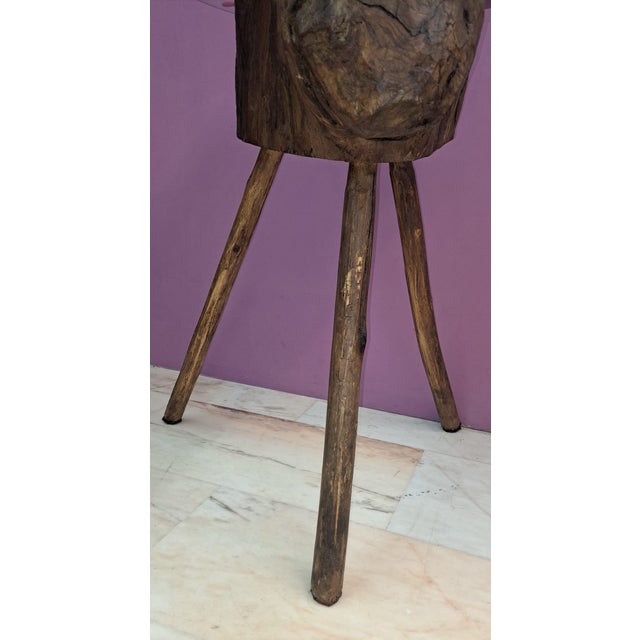 A butcher's block or stump from an old butcher shop, fitted with an oval glass top, creates a beautiful side table with a...