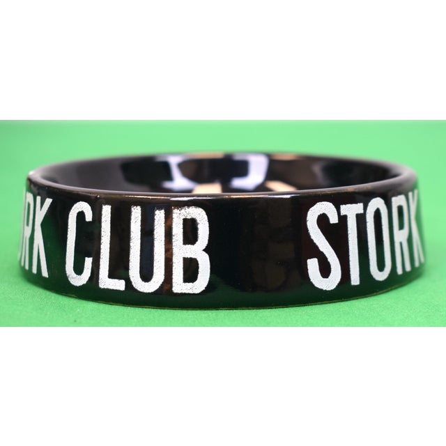 Sz: 4 3/4"Diamter x 1 1/4"Deep Cigarette Sz: 3"L Vintage, black-glazed ceramic ashtray featuring the club’s iconic white-...