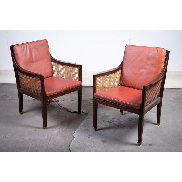 Elegant pair of Danish armchairs attributed to Fritz Henningsen, crafted in mahogany with refined brass-capped feet. The...