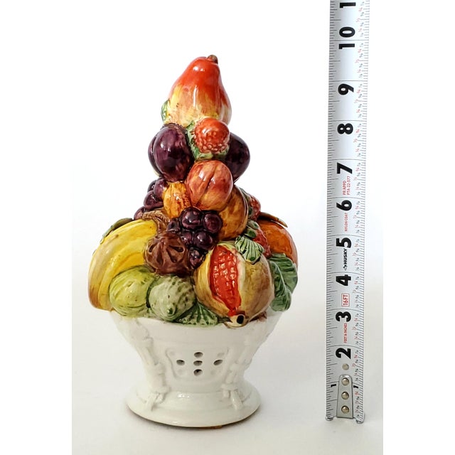 Offering a 1960s small Italian porcelain hand painted topiary depicting a white basket filled with an array of fruits...