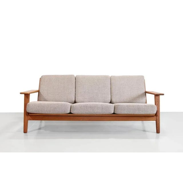 Beautiful classic by Hans J. Wegner for Getama in Denmark. This model, GE290, is a three-seater sofa made of solid oak. A...