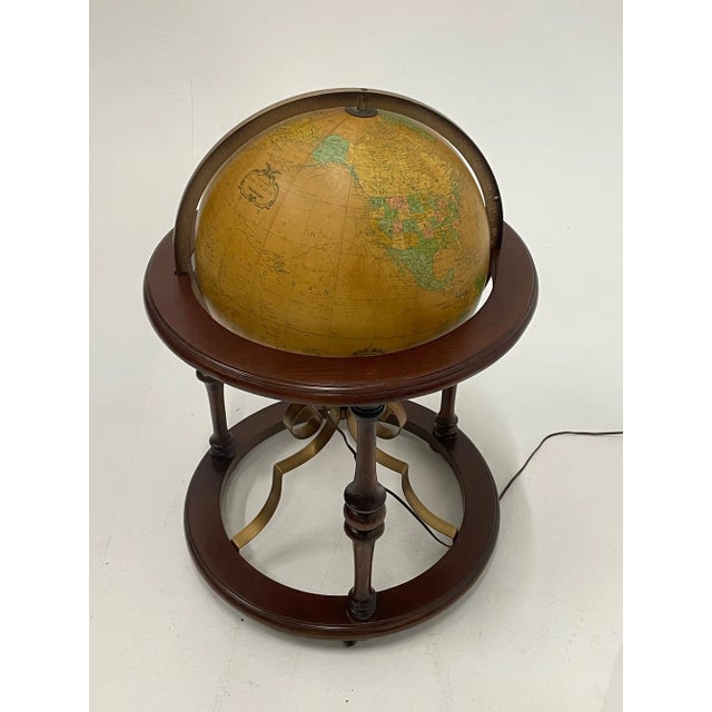 A beautiful large glass globe that illuminates and is contained in a handsome walnut and iron stand. Large enough to be...