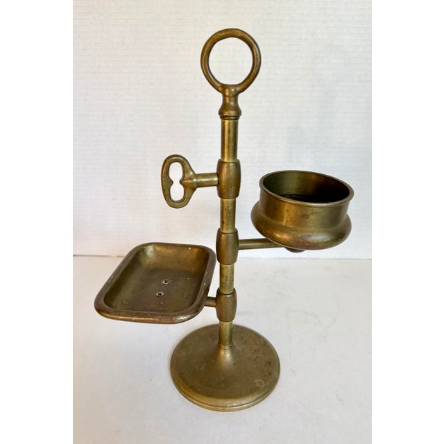 This early 20th century solid brass gentleman’s shaving grooming stand features a beautifully balanced vertical form with...