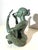 Elegant patinated bronze sculpture depicting a seated female figure holding a small hand mirror. The pose is serene and...