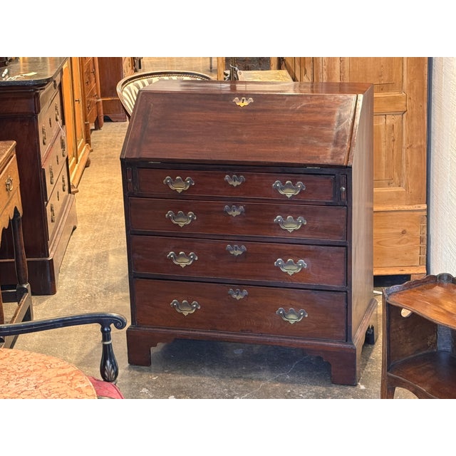 George III mahogany fall-front desk with a fitted interior of small drawers, open compartments, and a central cupboard...