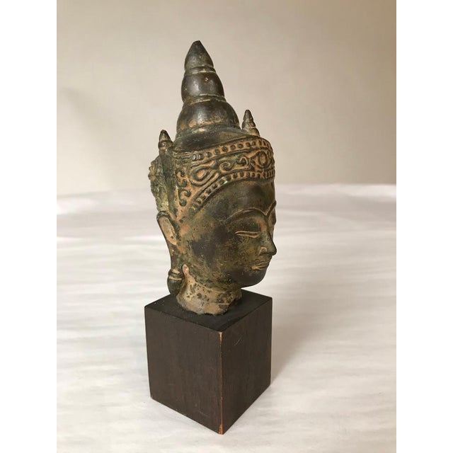 A Thai bronze head of Buddha, Sukothai period, late 16th-early 17th century. His face with serene expression, arched...