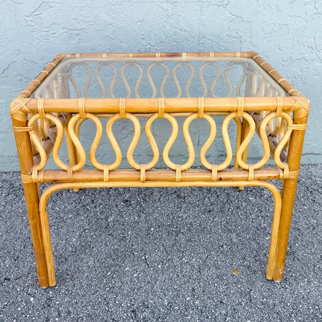 Charming vintage Boho Chic side table crafted from natural rattan with a warm honey-toned finish. The open frame features...