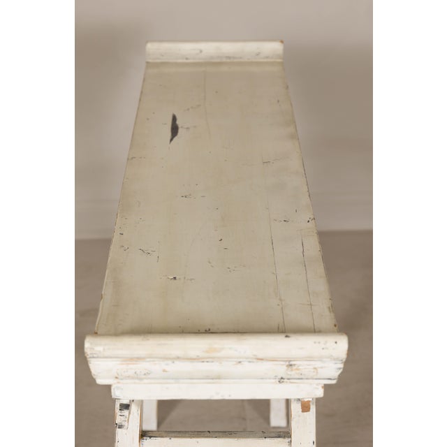 This vintage Chinese console table features a striking weathered white patina, exuding timeless charm and understated...