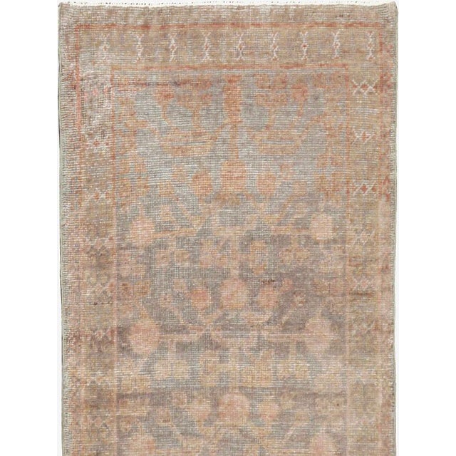 An antique East Turkestan Khotan rug in runner format with a pomegranate design handmade during the mid-20th century....