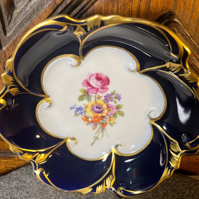 Fine quality. Rich cobalt blue porcelain dish with a floral design of pinks, purples, oranges, and yellows. Trimmed in a...
