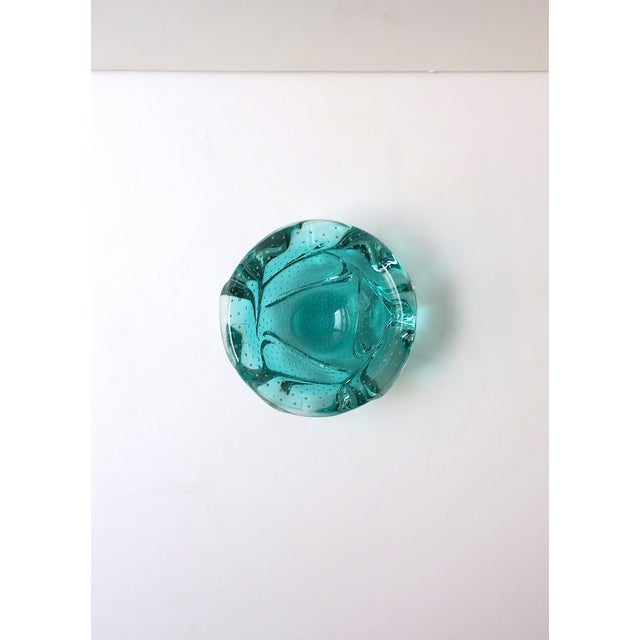 A sculptural Italian Murano art glass bowl in a saturated green hue, executed with a controlled bubble interior and an...