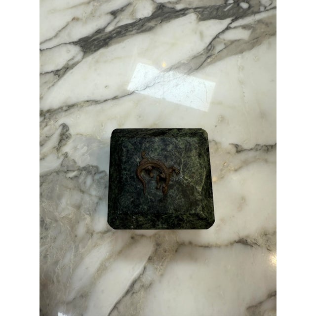 Elegant box is crafted from deep green marble with natural veining, giving it a refined and luxurious appearance. It rests...