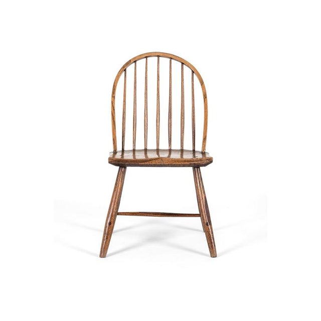 A simple primitive stick back low chair of excellent form. The chair exhibits a low bow stick back in ash with a...