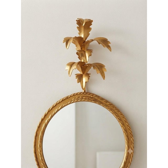 Pair of mid-century Italian gilded mirror sconces. These elegant pieces feature a refined floral motif and a classic gold...
