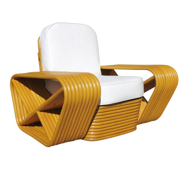 Beautifully restored Paul Frankl style rare ten-strand square pretzel rattan lounge chair with stacked rattan base. The...