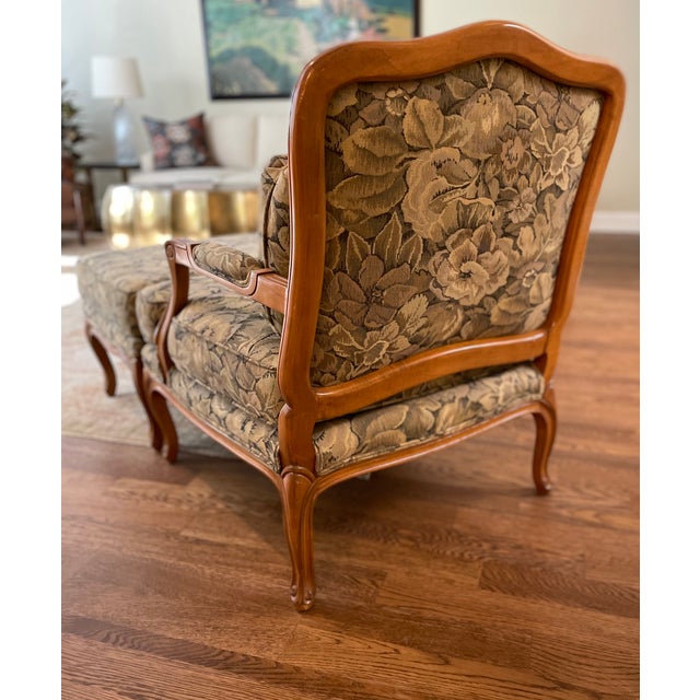 Elegant French Provincial lounge chair and matching ottoman featuring a beautifully carved solid wood frame with graceful...