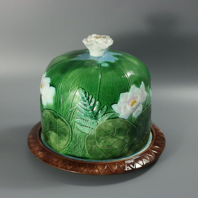 Holdcroft Majolica cheese keep which features fern fronds, and pond lily leaves and flowers. Colouration: green, white,...