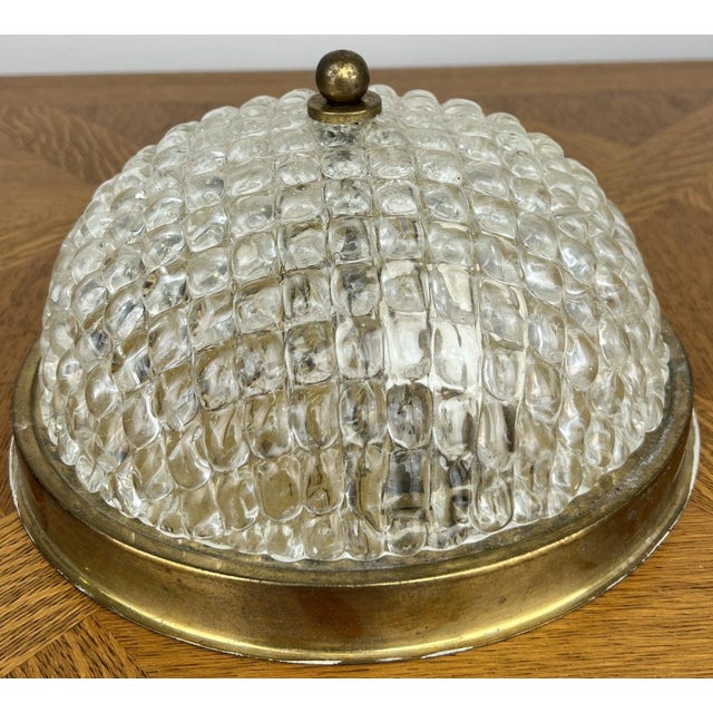 A charming Vintage French ceiling lamp featuring a beautifully textured glass shade mounted within a classic brass...