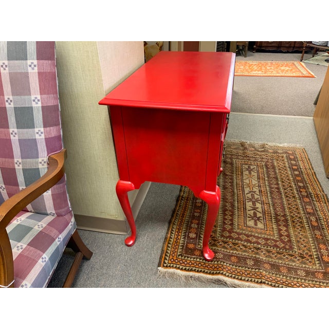 20th century lowboy. Painted red over original finish. Shell design detail, pad feet cabriole legs. Four drawers. Marked...