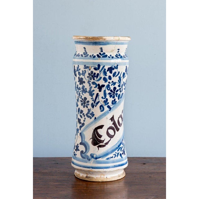 An 18th-century Spanish albarello jar from Catalonia, decorated with a scrolled label bearing elegant black lettering,...