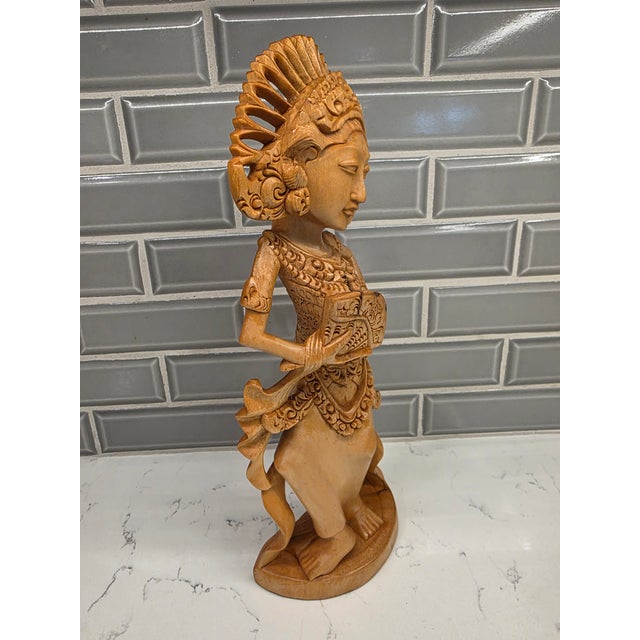 This is an amazing, beautifully preserved late 20th-century Balinese modernist wood carving depicting a young Janger fan...