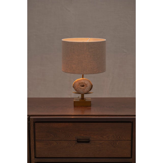 Striking French table lamp from the 1970s, attributed to Willy Daro, featuring a natural agate geode mounted within an...