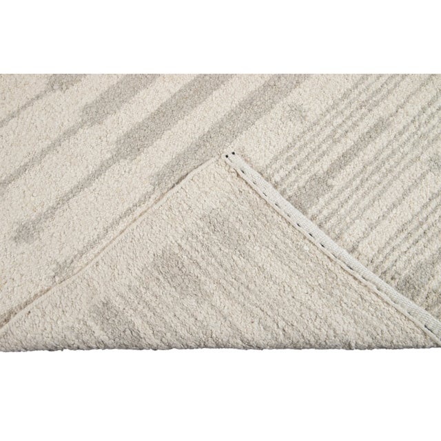 Beautiful Moroccan style handmade wool rug with an ivory field. This Moroccan rug has accents in gray in a gorgeous all-...